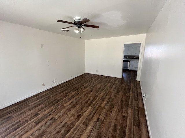 empty room with ceiling fan and dark hardwood / wood-style flooring