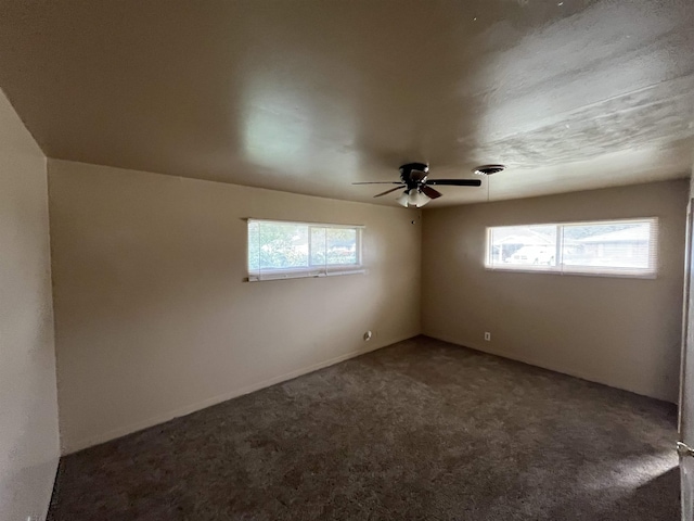 carpeted empty room featuring ceiling fan and a wealth of natural light