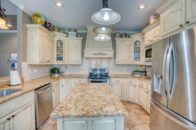 kitchen with custom exhaust hood, light stone counters, stainless steel appliances, and hanging light fixtures