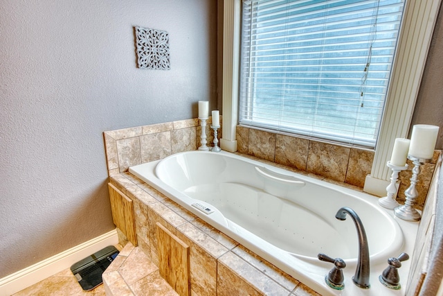 bathroom featuring tile patterned flooring and tiled tub