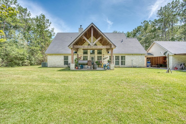 back of house with central AC unit and a lawn