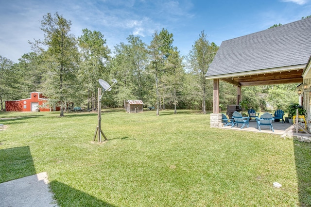 view of yard with a patio area, an outdoor living space, and an outdoor structure