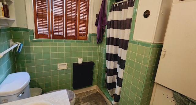 bathroom with curtained shower, tile walls, and toilet