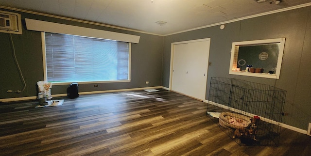 interior space featuring a wall mounted air conditioner, dark hardwood / wood-style floors, and crown molding