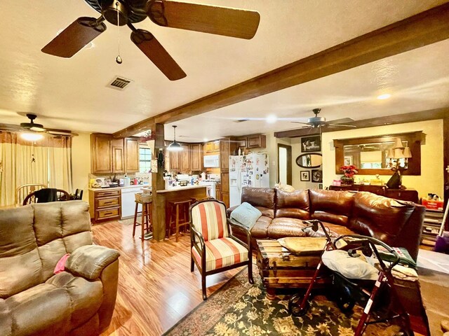 living room with beamed ceiling and light hardwood / wood-style floors