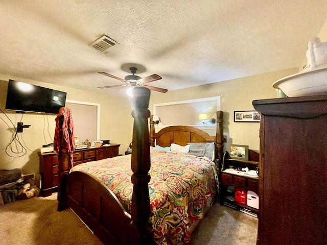 bedroom featuring ceiling fan, carpet floors, and a textured ceiling