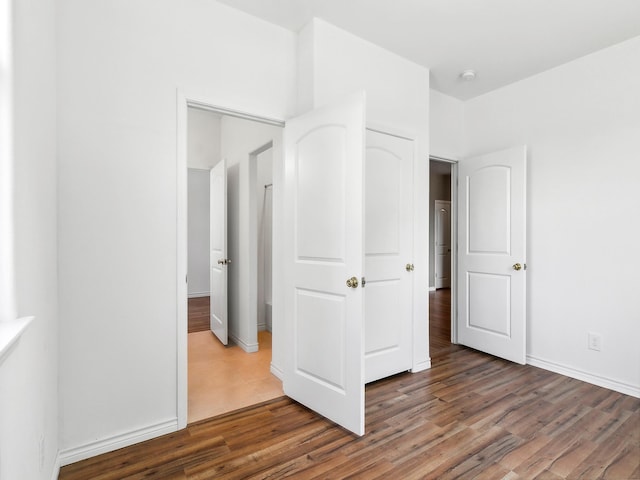 unfurnished bedroom featuring wood finished floors and baseboards