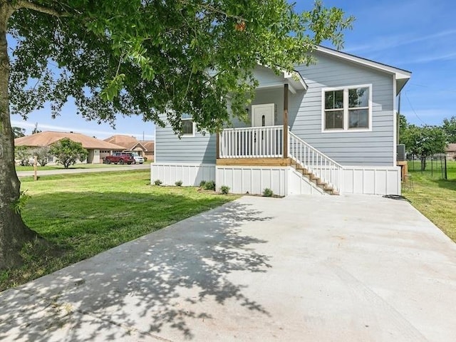 manufactured / mobile home with covered porch and a front yard