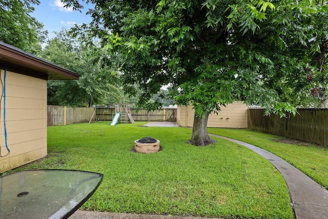 3449 Charles Ave, Groves, TX 77619 - fenced backyard featuring a playground and an outdoor fire pit