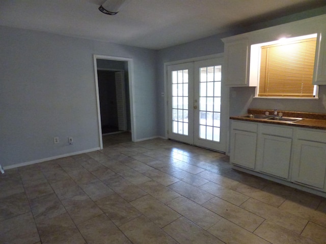 unfurnished dining area featuring light tile patterned floors, sink, and french doors