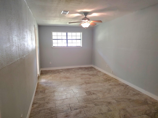 unfurnished room featuring ceiling fan and a textured ceiling