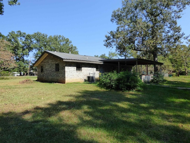 exterior space with central air condition unit, a yard, and solar panels