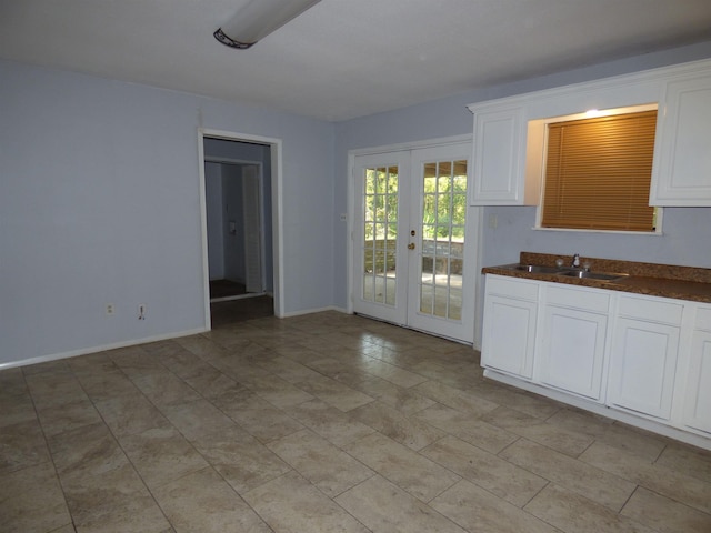 kitchen featuring white cabinetry, french doors, and sink