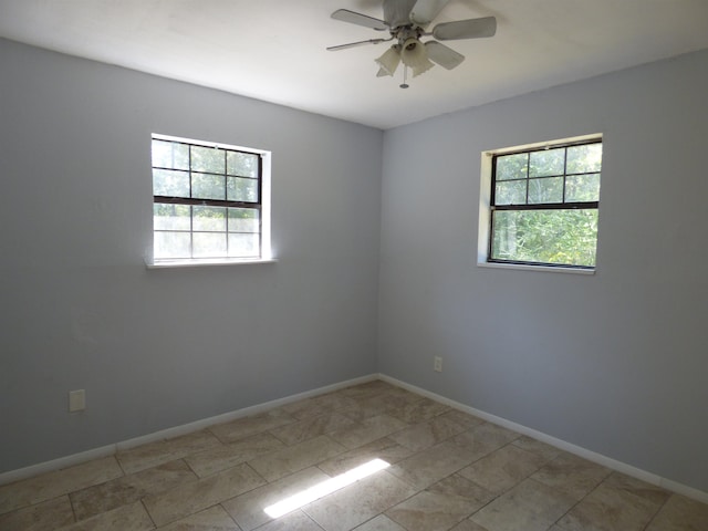 tiled empty room featuring ceiling fan