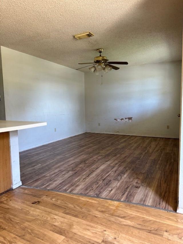 spare room featuring hardwood / wood-style floors, ceiling fan, and a textured ceiling