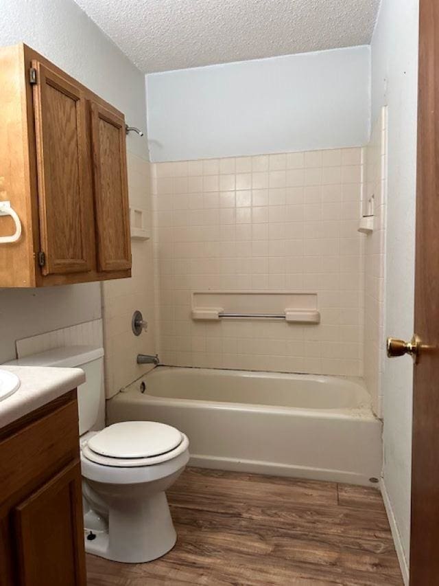 full bathroom featuring vanity, a textured ceiling, toilet, shower / bathing tub combination, and hardwood / wood-style flooring