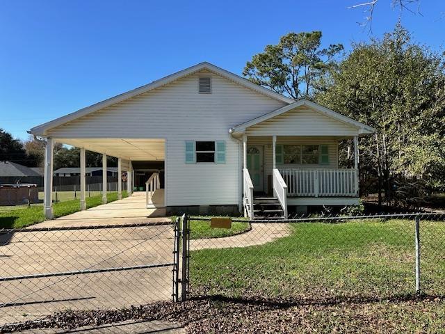 view of front of home featuring a front yard, a carport, and covered porch