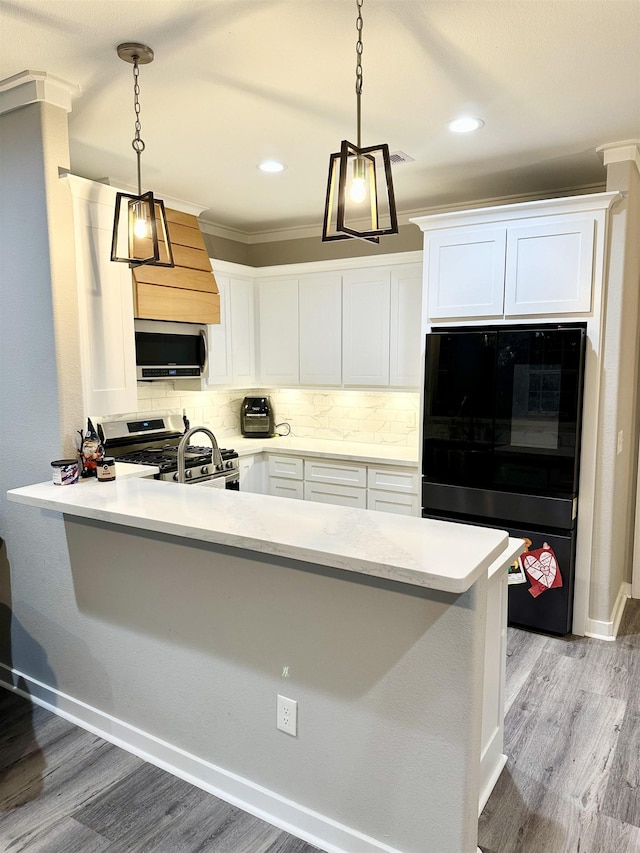 kitchen with white cabinetry, backsplash, light wood-style flooring, a peninsula, and appliances with stainless steel finishes