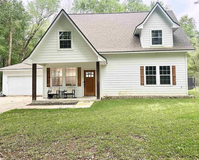 view of front of house featuring a garage, concrete driveway, a front lawn, roof with shingles, and covered porch