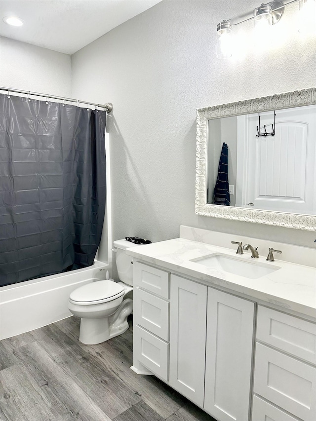 bathroom with toilet, vanity, shower / bath combo, and wood finished floors