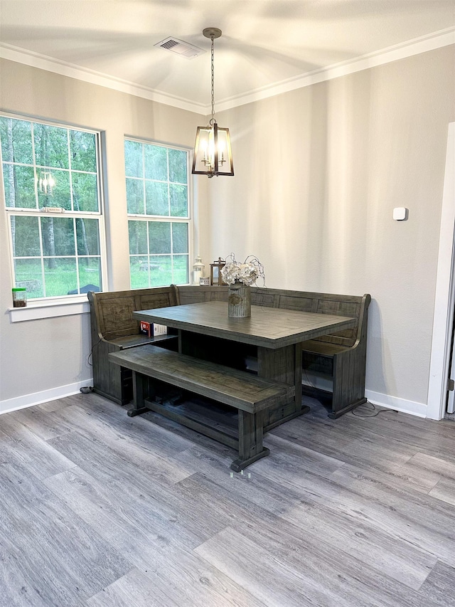 dining area featuring breakfast area, crown molding, wood finished floors, and a chandelier