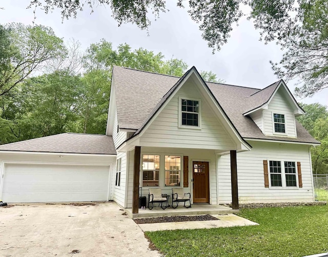 view of front facade featuring roof with shingles, an attached garage, a porch, and concrete driveway