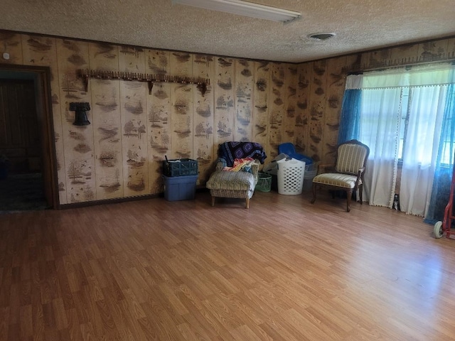 unfurnished room with hardwood / wood-style flooring and a textured ceiling