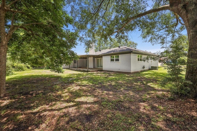 2024 International Ave, Orange, TX 77632 - back of house featuring a chimney, brick siding, a yard, and a patio