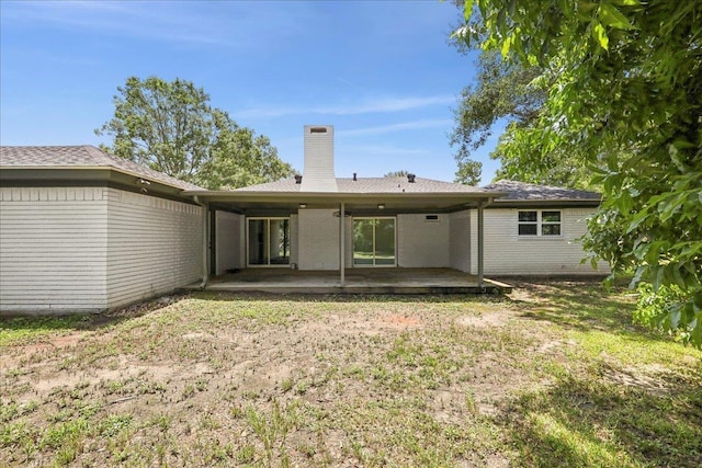 2024 International Ave, Orange, TX 77632 - back of house featuring a chimney, a patio, and brick siding