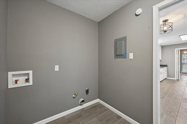 2024 International Ave, Orange, TX 77632 - laundry room featuring electric panel, hookup for a washing machine, hookup for a gas dryer, wood finished floors, and a textured ceiling