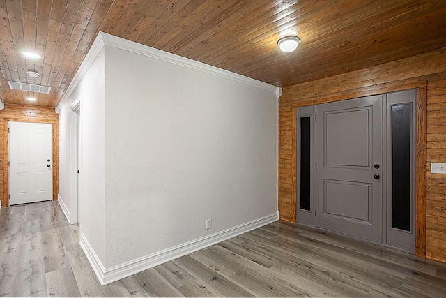 spare room featuring ornamental molding, wood ceiling, and light wood finished floors