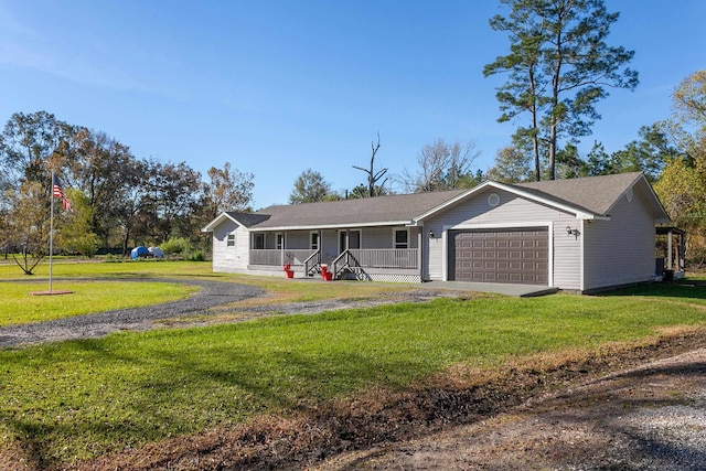 single story home featuring an attached garage, driveway, a porch, and a front yard