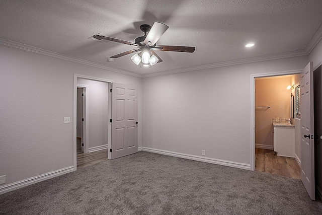 unfurnished bedroom featuring ornamental molding, dark colored carpet, and a textured ceiling