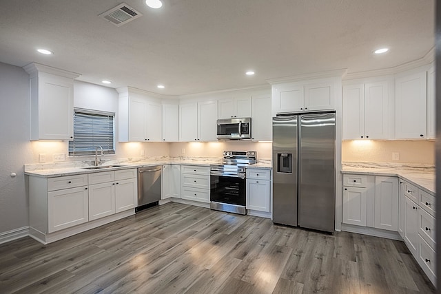 kitchen with stainless steel appliances, a sink, visible vents, and white cabinets