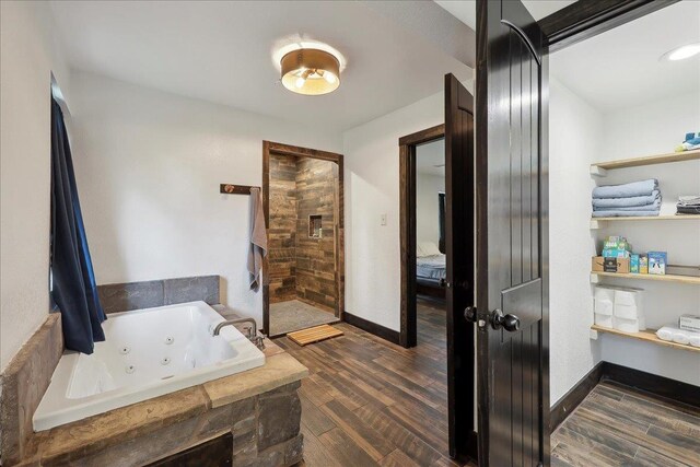 1185 Pinecrest St, Vidor, TX 77662 - bathroom featuring a whirlpool tub, wood finished floors, and baseboards