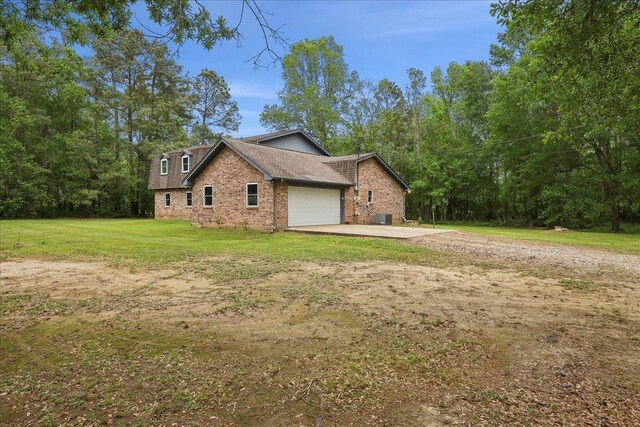 1185 Pinecrest St, Vidor, TX 77662 - view of side of property with brick siding, driveway, a garage, central AC, and a lawn