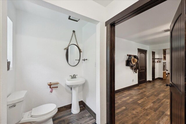 1185 Pinecrest St, Vidor, TX 77662 - bathroom featuring wood finished floors, toilet, baseboards, and a sink