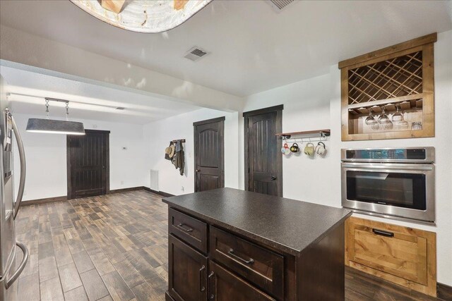 1185 Pinecrest St, Vidor, TX 77662 - kitchen featuring appliances with stainless steel finishes, dark countertops, dark wood-style flooring, dark brown cabinetry, and baseboards