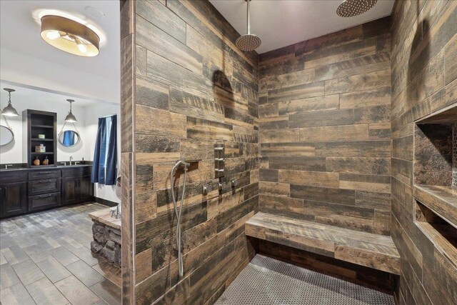 1185 Pinecrest St, Vidor, TX 77662 - bathroom featuring tiled shower, double vanity, and wood walls