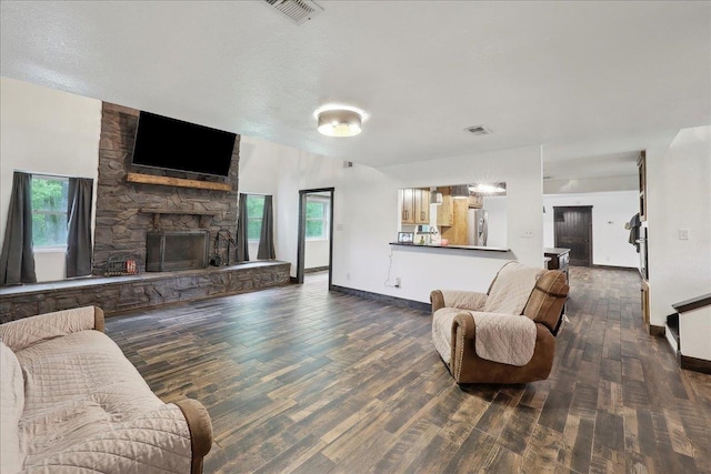 1185 Pinecrest St, Vidor, TX 77662 - living area with wood finished floors, a stone fireplace, and baseboards