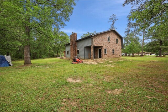 1185 Pinecrest St, Vidor, TX 77662 - back of property featuring a chimney, brick siding, and a yard