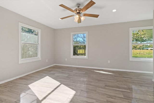 spare room with ceiling fan and a healthy amount of sunlight