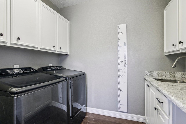 laundry room with washer and clothes dryer, cabinets, sink, and dark wood-type flooring