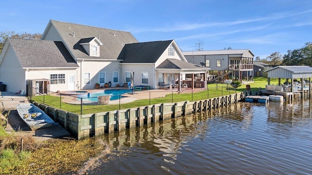 rear view of house featuring a fenced in pool, a yard, a water view, and a patio