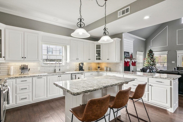 kitchen featuring a center island, white cabinetry, sink, and a breakfast bar area