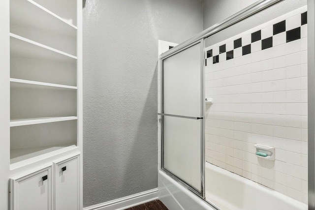 bathroom with hardwood / wood-style floors and enclosed tub / shower combo