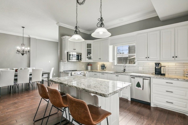 kitchen featuring pendant lighting, white cabinetry, sink, and appliances with stainless steel finishes