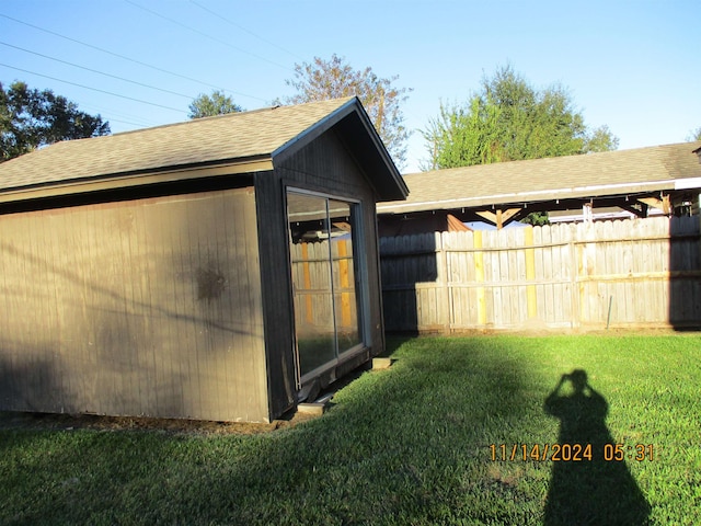 view of side of property featuring a lawn and an outbuilding