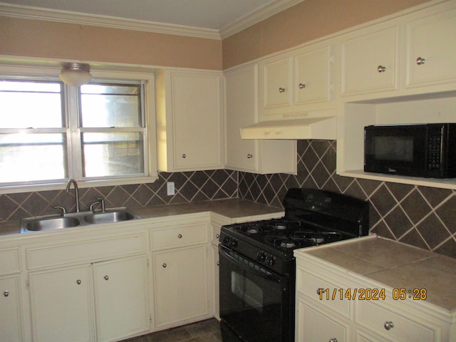 kitchen featuring black appliances, decorative backsplash, custom range hood, and sink