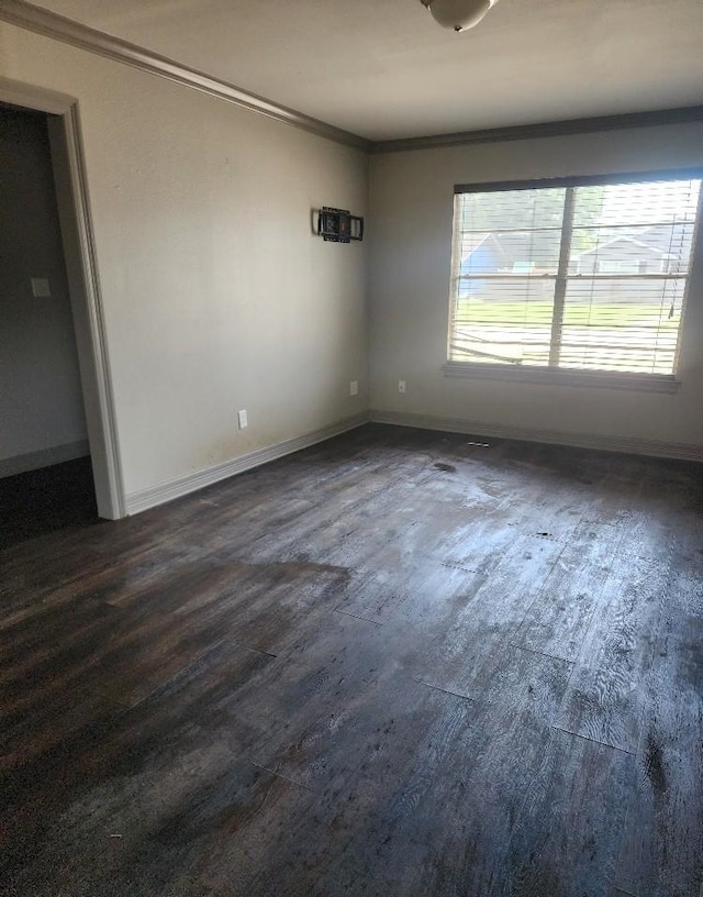 empty room featuring crown molding and dark hardwood / wood-style flooring